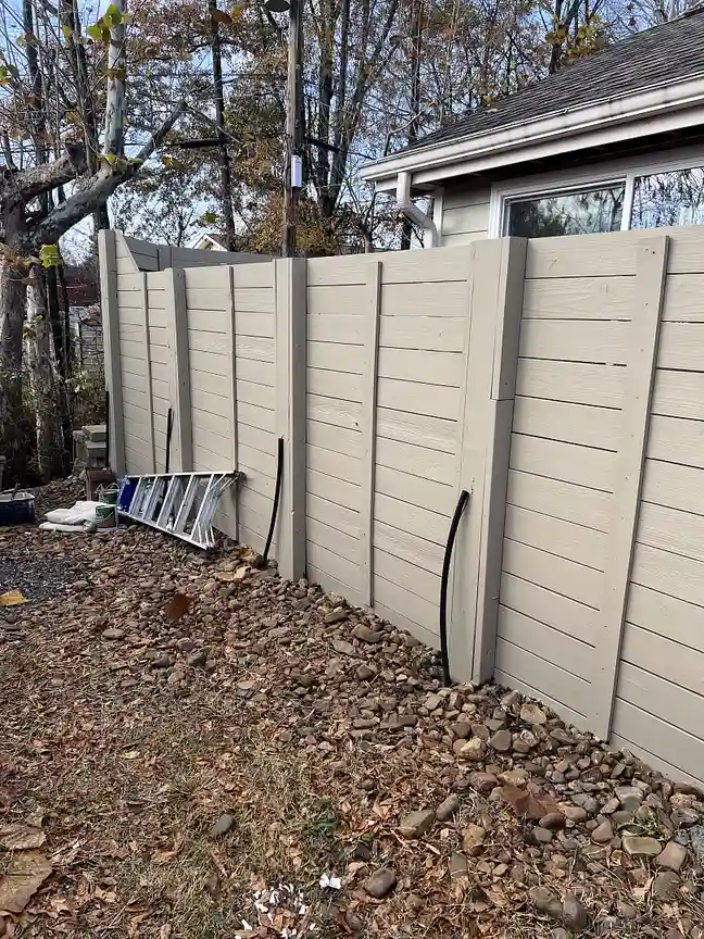 Painter applying fresh paint to a home exterior wall